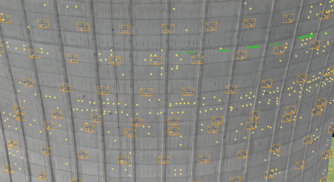 Camera positions and mapped damage on the water tower’s surface. The yellow pinpoints represent corrosion spots and green surfaces display the spalling region.